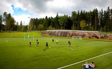 Bild på ungdomar som tränar på en fotbollsplan.