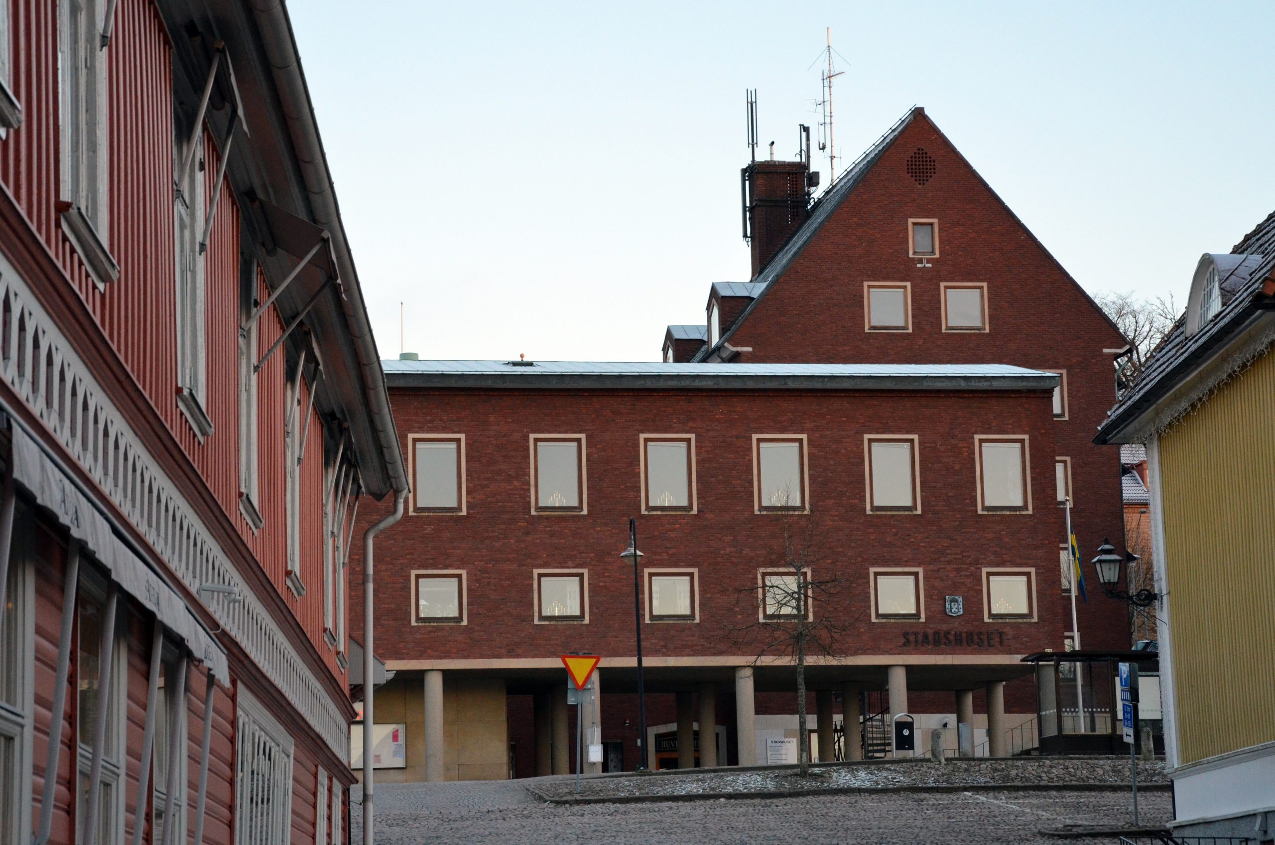 Bild på stadshuset taget från Bogesundsgatan. Huset är en röd tegelbyggnad i vinkel och i flera våningar.