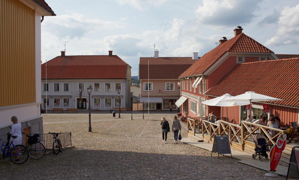 Bild på stora torget i Ulricehamn med kullerstenar och trähus runt omkring.