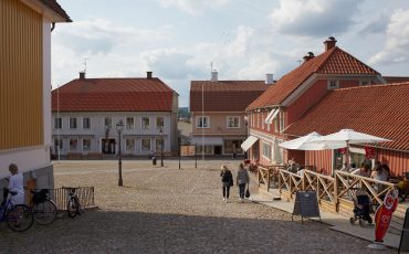 Bild på stora torget i Ulricehamn med kullerstenar och trähus runt omkring.