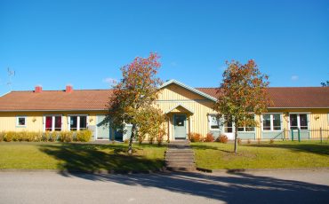 Bild på Hästhovens förskola som är ett envåningshus i gult trä och rött tak.