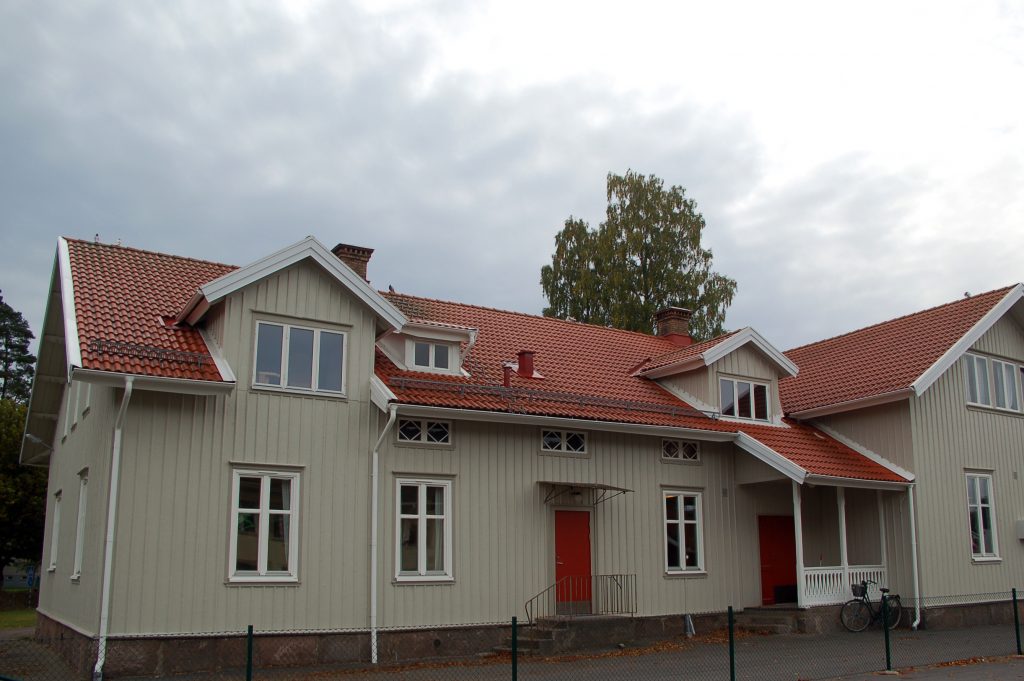 Bild på Nyckelpigans förskola som är beige träbyggnad med vackert rött tegeltak och röda dörrar.