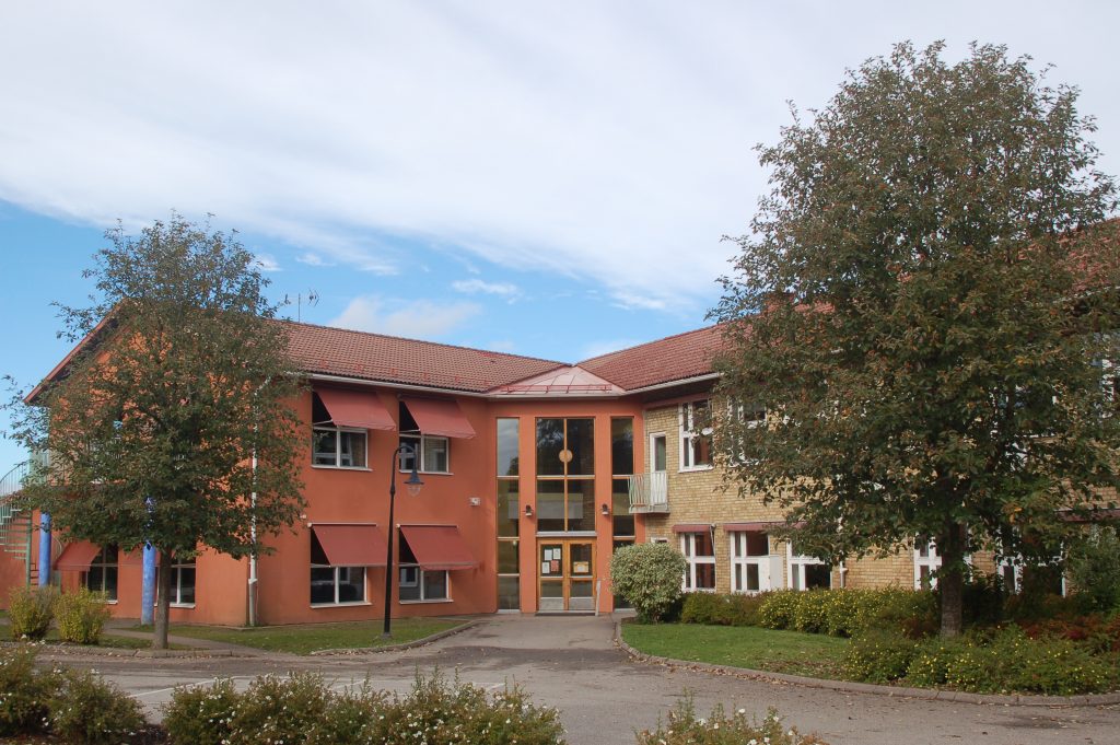 Bild på Hökerums skola som har två våningar och är byggd i terrakottafärgad och beige puts