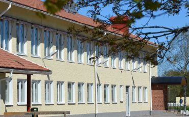 Bild på delar av Timmele skola som är en ljusgul stenbyggnad i två våningar