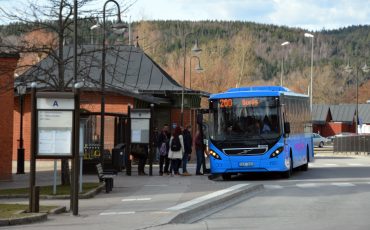 Blå buss framför en busshållplats
