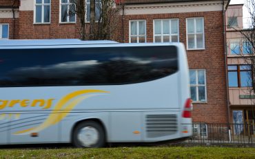 Bild på en buss som kör förbi utanför Stenbocksskolan