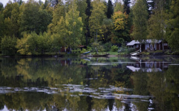 Bild på en stuga vid en sjö