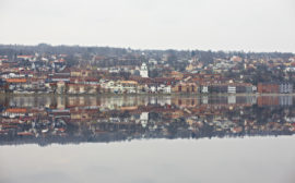 Spegelblankt Åsundenvatten och sedan en stadsvy.