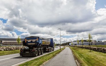 Bild på en väg och en cykelväg. En lastbil åker på vägen.