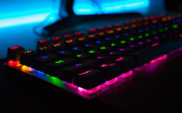 Ett tangentbord som lyser under tangenterna i blått, lila, grönt och rött.