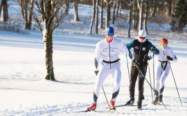 Två längdskidåkare åker skidor utomhus.