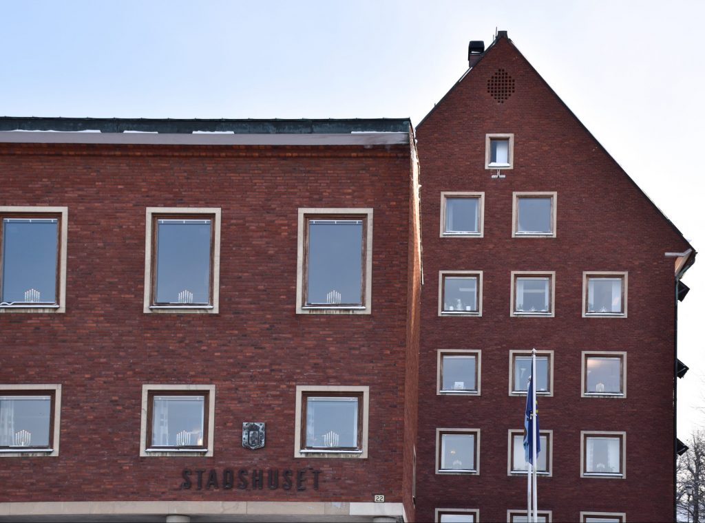 Stadshuset med adventsljusstakar i fönstren