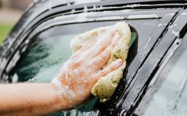 Person som tvättar en bil