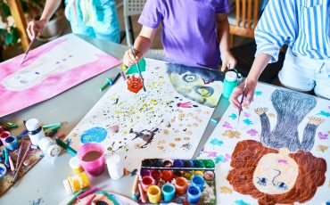 Barn målar med vattenfärger