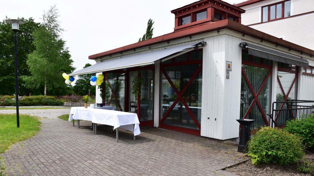 Vit byggnad smyckad med blå och gula ballonger