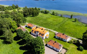 Vit byggnad med två flyglar vid sjö