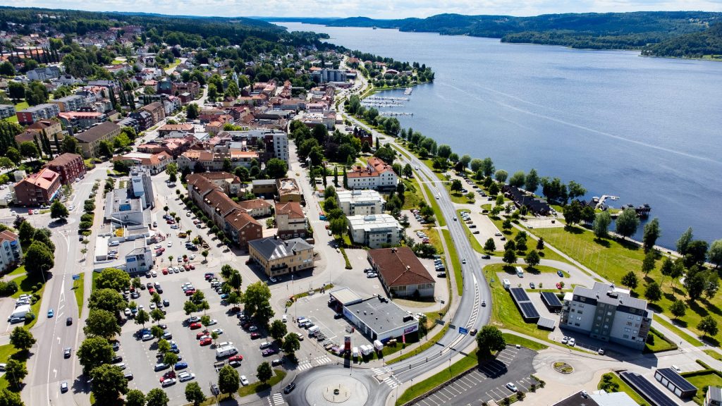 Vy över stadskärna vid sjö under sommartid