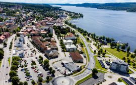 Vy över stadskärna vid sjö under sommartid