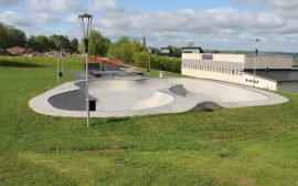 en går skateparke i runda former, omgiven av gräsmatta och grönytor