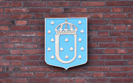 Ulricehamns kommunvapen, en blå vapensköld med bokstaven "U" och en krona.